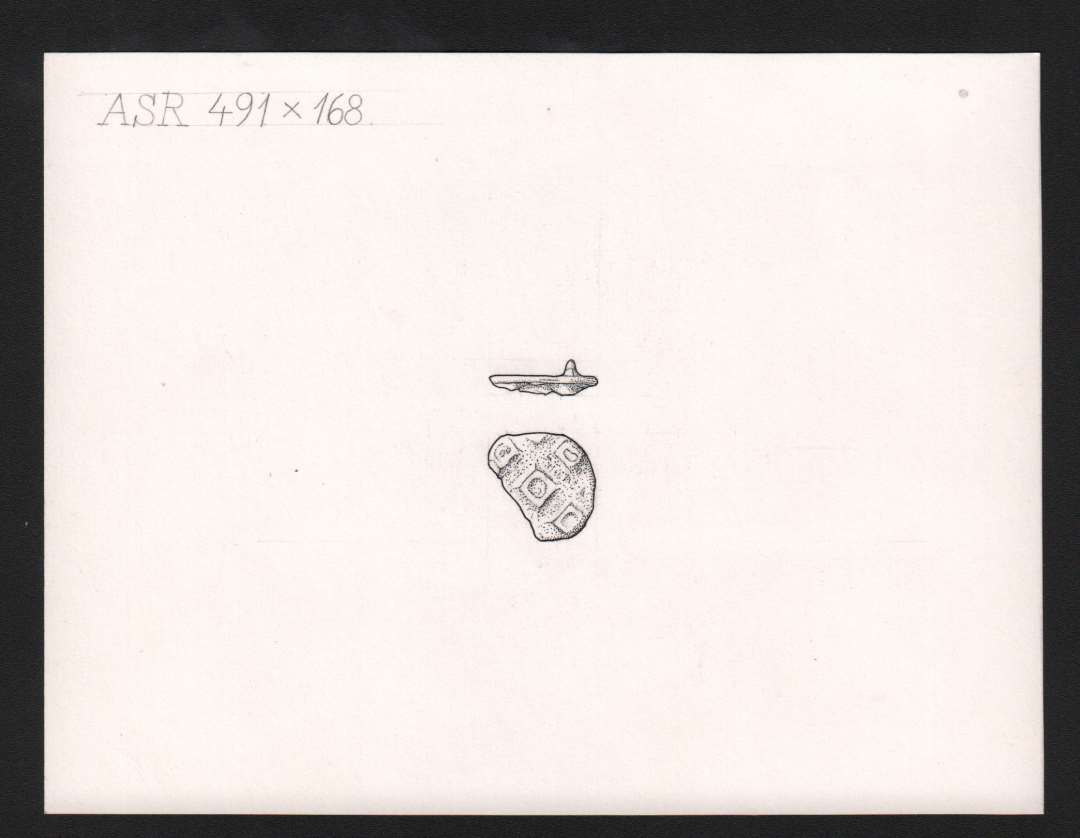 Cirkul�rt emaljesp�nde, del af n�leholder p� bagsiden. P� forsiden fem (fire bevaret) sm� kvadratiske oph�jede rammer, hvori der ant. har v�ret emalje. Diameter: 20 mm.