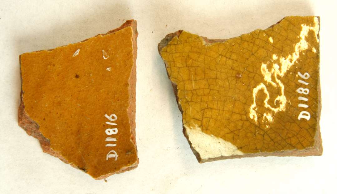 1 side- og 1 bundsk�r af r�dbr�ndte lersk�le (?). Indvendig begitning og klar blyglasur. Gr. 1.