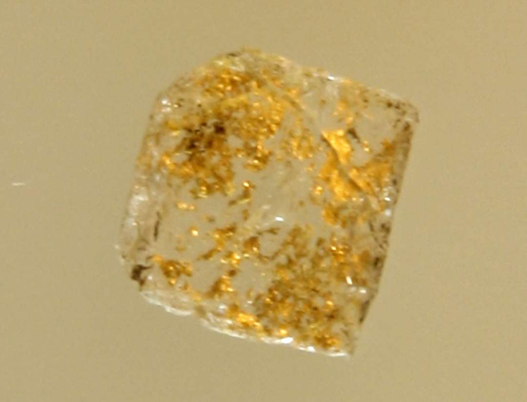 1 omtrent kvadratisk skive af gennemsigtigt hvidt glas med rester af guldfoliebel�gning p� den ene fladside. Fragment af mosaikstift.�St. m�l: 0,9 x 0,9 x 0,1 cm.