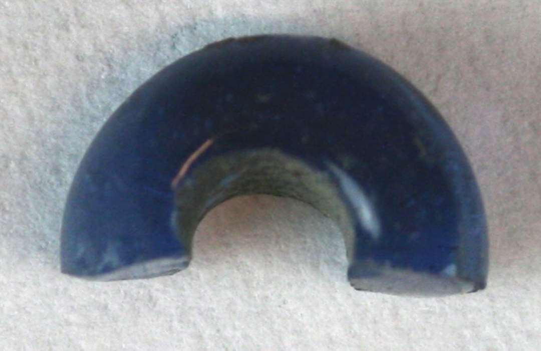 2 halve perler (ikke samh�rende) af afrundet ringform og af bl�ligt gennemsigtigt glas. a: 11 mm., b: 11 mm.