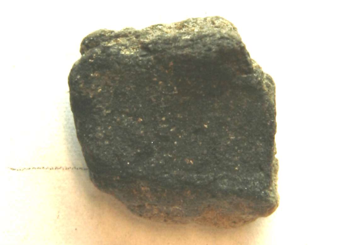 1 fragment af st�beformshalvdel af gr�brunt, fintmagret, br�ndt ler med fors�nket afglattet flade p� indersiden. M�l: 1,9 x 2,0 cm. Tyk: 1,1 cm.