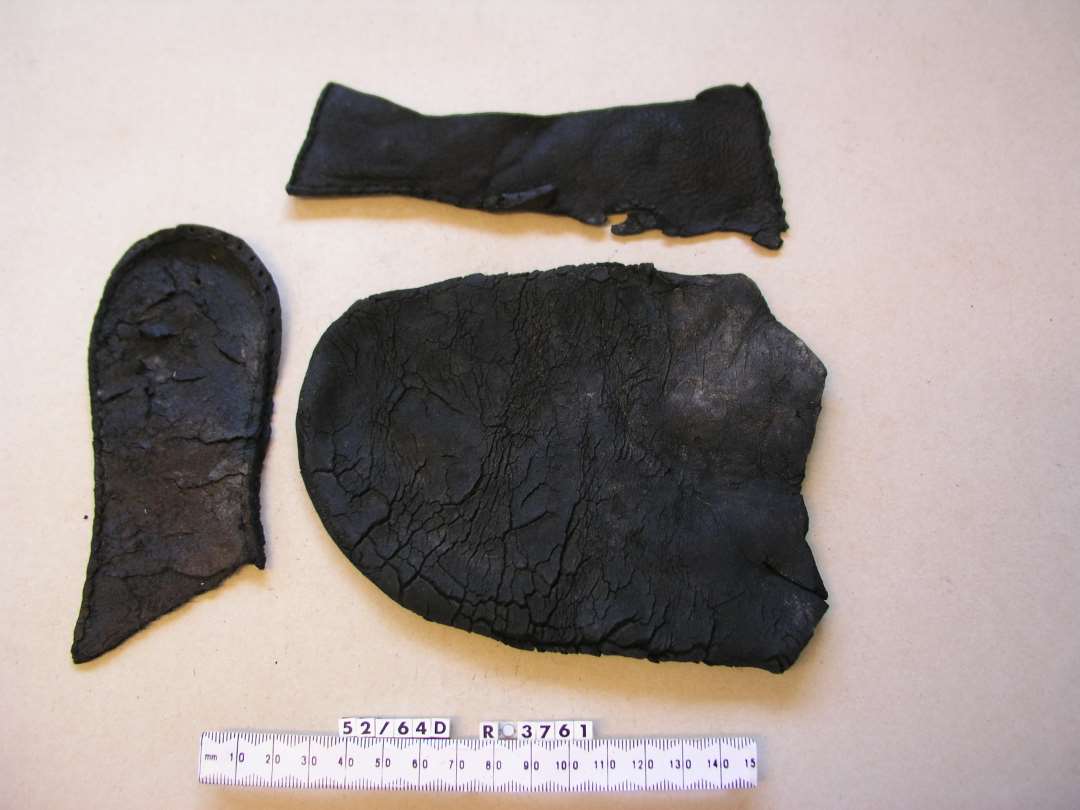 1 s�l, 1 stykke overl�der, 1 stykke l�der med syning, Overl�derfragment:�St�rst L�ngde 16 cm. St�rst Bredde ca. 18 cm. Forpartiet af et kraftigt Overl�der til en voksen Sko med bredt afrundet N�separti. De fleste Saale og S�mkanter er Bevaret: Saalfragment, l�der: St�rste L�ngde: ca. 13,8 cm. H�lpartiet af Skosaal til voksen Person skraat afrevet Svangen. Overl�der fragment: St�rste L�ngde: 16 cm. St�rste Bredde: ca. 6,5 cm.�Overl�derfragment fra Side- eller H�lparti af Sko. S�mkanterne i Siderne er bevaret, medens S�mkanten mod Saalen til dels er borte. Er antagelig samh�rende med Overl�deret R03761.