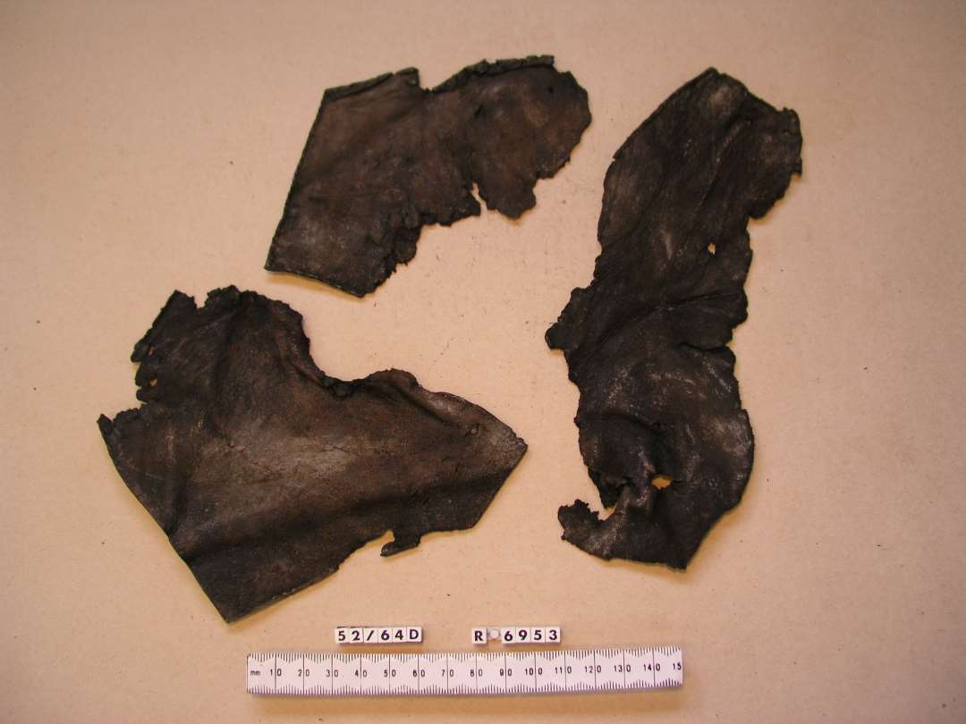 Tre Overl�derfragmenter antagelig hidr�rende fra en og samme St�vle til halvvolsen Person.�S�msporene viser at St�vlen har v�ret tilskaaret af flere Stykker L�der.�Lukningen er foregaaet ved Hj�lp af L�derremme trukket gannem flere over hinanden anbragte �jer.