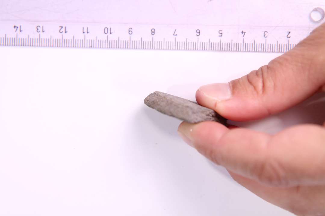 Fragment af glimmerskifer. Sandsynligvis af cirkul�r genstand med afrundet kant. Spillebrik? st�rste m�l: 4,2 cm.