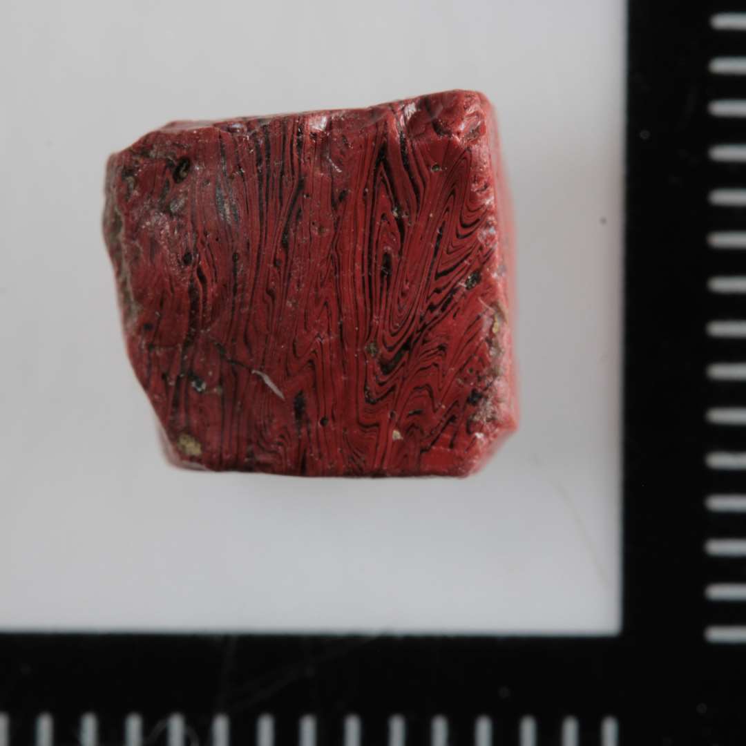 1 mosaikstift af uigennemsigtig r�dbrunlig glasmasse.