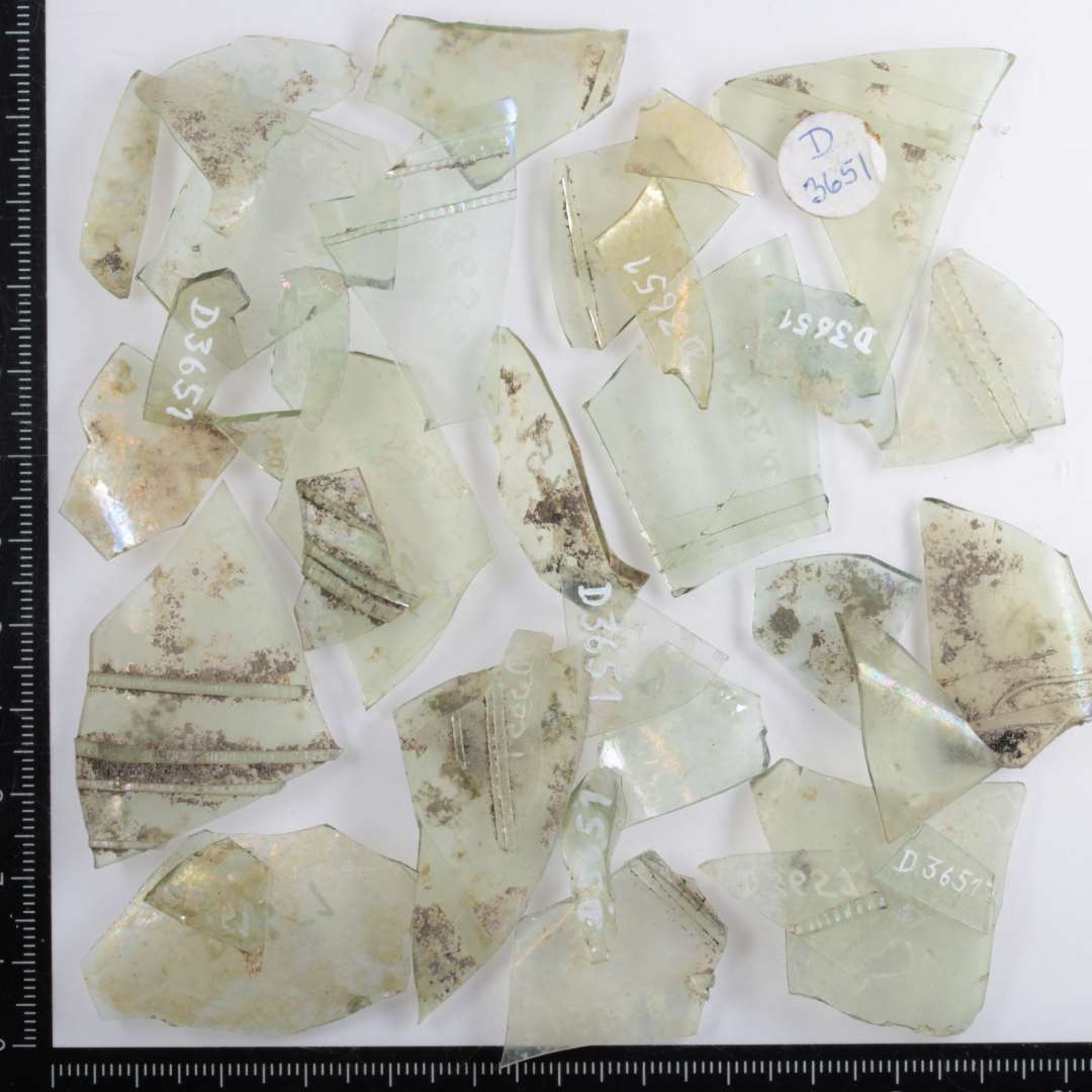 33 mindre fragmenter fra siden af flerkantede drikkeglas af klart, let gr�nligt glas b�de med og uden p�lagte glasb�nd af glas p� ydersiden stangenglas.