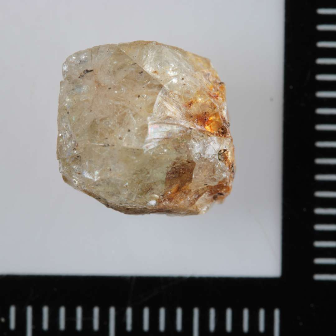 1 mosaikstift af gr�ligt, delvis gennemsigtigt, st�rkt revnegennemtrukket glas med rest af guldfoliebel�gning p� den ene flade.