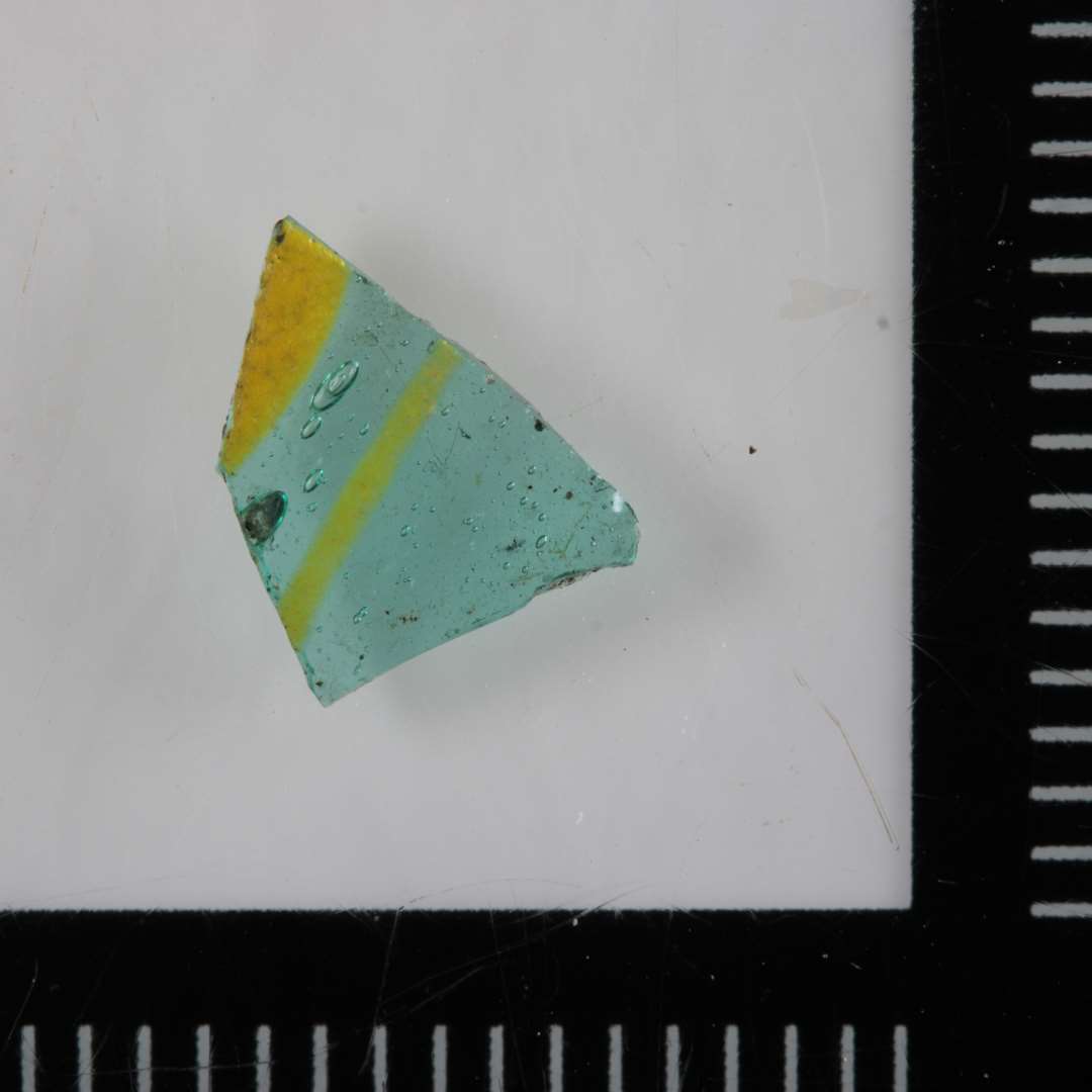 1 sk�r af drikkeglas. Klart gr�nt gennemsigtigt glas med 1 indsmeltet stribe og en p�lagt gul stribe.