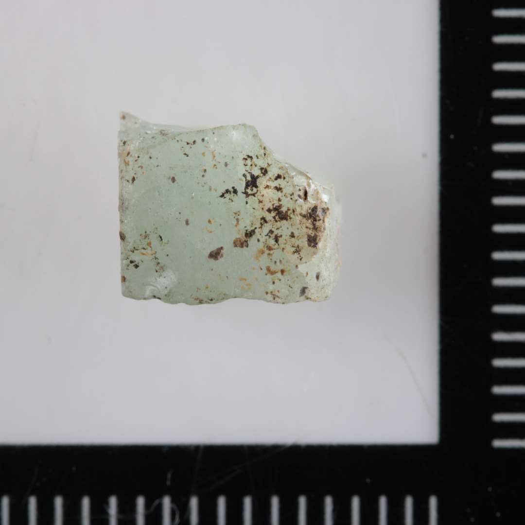 1 fragmenteret mosaikstift af hvidgr�t, delvis gennemsigtig glas.