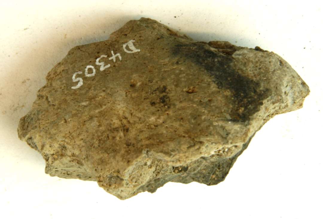 1 fragment af discosformet v�vev�gt af gr�brunlig br�ndt lermasse. St�rste m�l: 7 cm.
