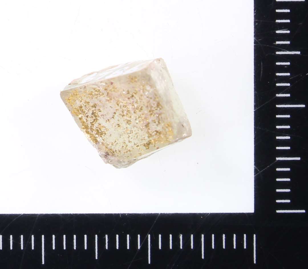 1 mosaikstift af uregelm�ssig kubisk form og af hvidt gennemsigtigt glas med rester af guldfoliebel�gning p� den ene side.�