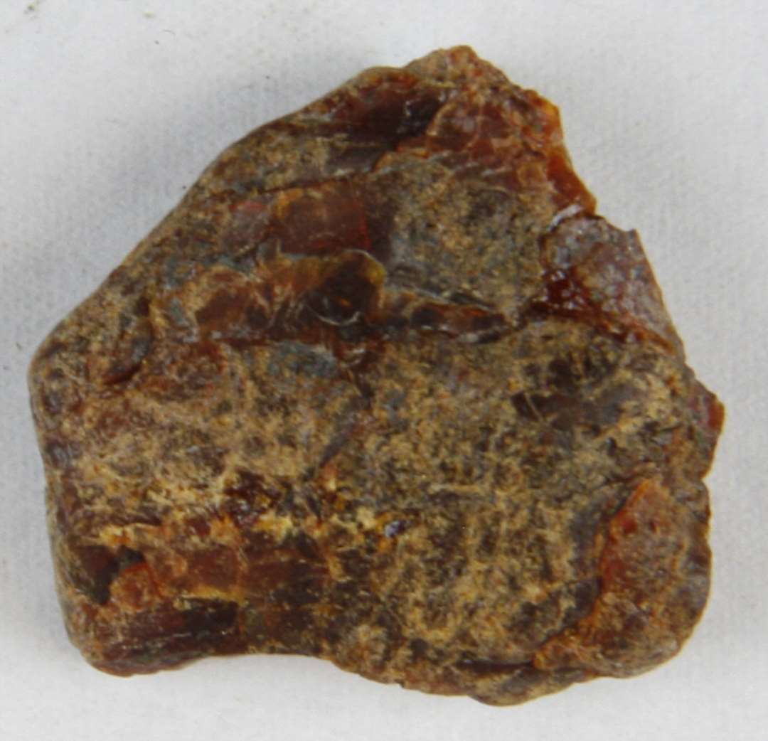 1 fladt stykke uforarbejdet rav.�Tv�rm�l: 2,3 x 2,4 cm.�Tykkelse: 0,4 cm.