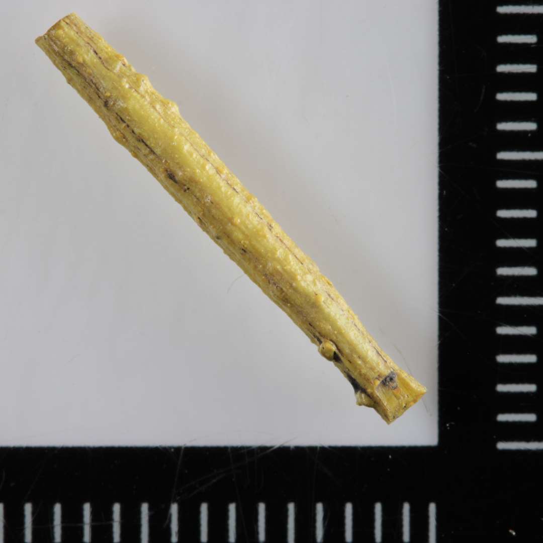 1 tynd stang af gult, ugennemsigtigt glas med svagt rillet overflade.�L�ngde:  1,8 cm.�diameter: 0,2 cm.