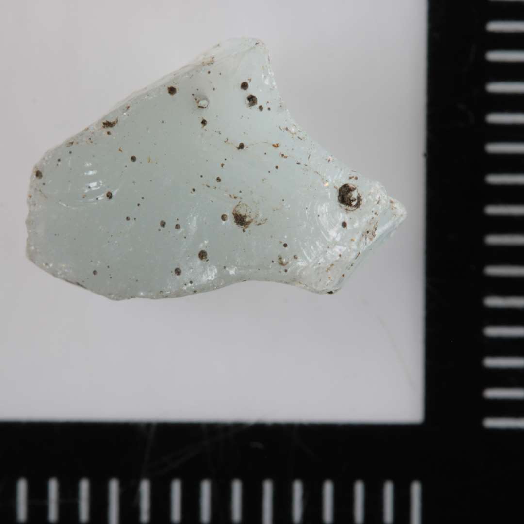 1 mosaikstift af hvidligt, ugennemsigtigt glas.�St. m�l: 1,0 x 0,9 x 0,5 cm.