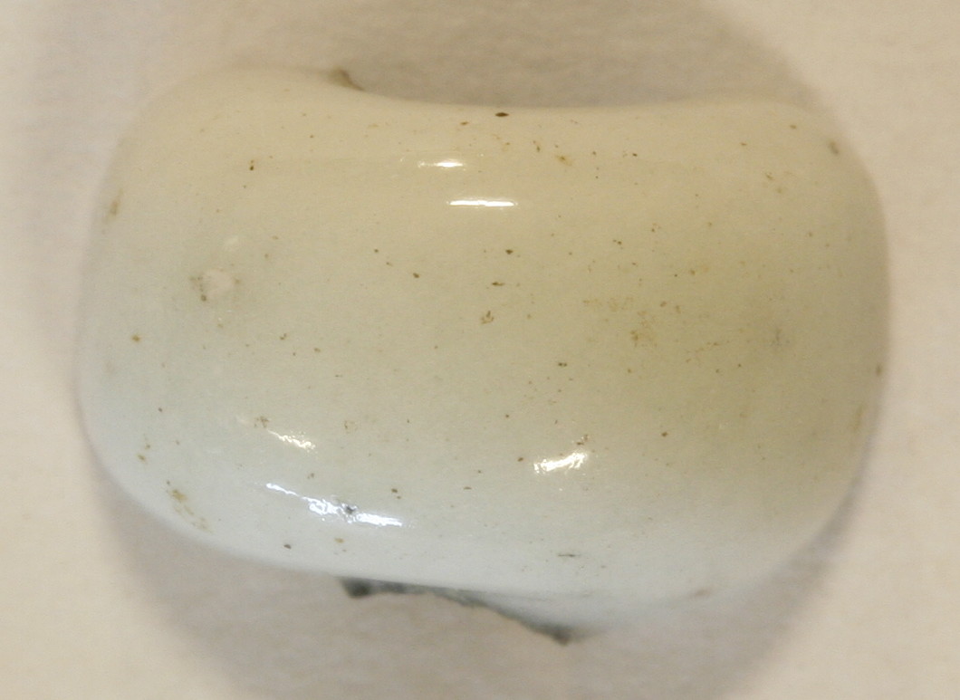 � tyk ringformet perle af hvidgr�, ugennemsigtig glasmasse.�Diameter: 0,9 cm.�Tykkelse:  0,6 cm.