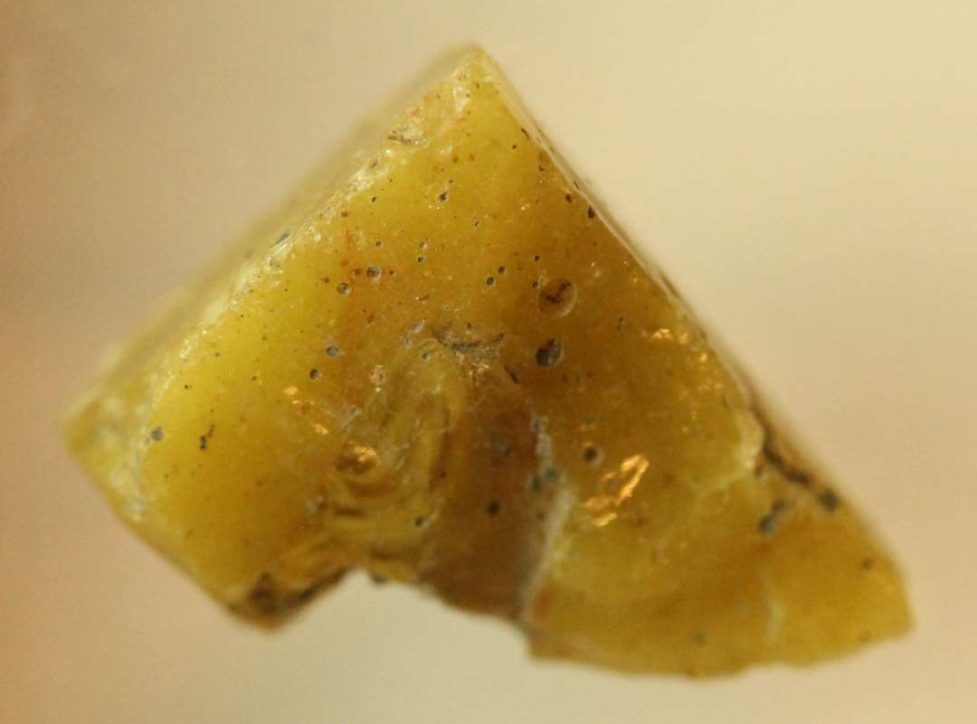 1 mosaikstift af uregelm�ssig form og af grumsetgullig, ugennemsigtigt glas.�st. m�l: 1,4 x 1,1 x 0,9 cm.