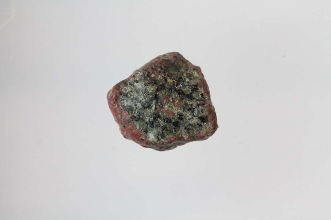 1 fragment af overbrudt glasstang dannet af talrige sammensmeltede bl� og gule glastr�de. Imidten og langs kanten ugennemsigtigt r�dt glas.�St. m�l: 0,7 x 0,6 x 0,4 cm.