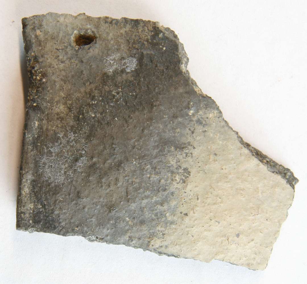1 randsk�r af gr�br�ndt, magret lergods fra kar med indadb�jet rand og lige affaset indadskr�nende randoverkant. 1 klinkhul findes under randkanten (halvkuglekar) og 3 sidesk�r fra samme kar.