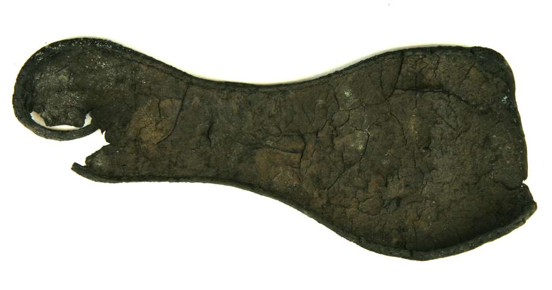 Fragmenteret l�ders�l til h�jre fod p� voksen person. H�len, der er noget beskadiget, har afrundet udbuet form, medens vristen har langstragt indsvungen form. Fodbladspartiet har st�rkt udadsvungne sider, men er lige oversk�ret i n�separtiet, hvoraf ca. den yderste fjerdedel har v�ret suppleret med et andet stykke tilsk�ret l�der. St�rste l�ngde: 25,0 cm. St�rste h�lbredde: 6,6 cm. St�rste vristbredde: 4,8 cm. St�rste fodbladsbredde: 10,1 cm.