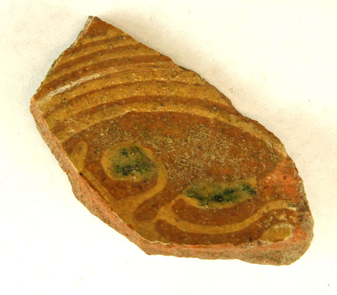 1 bundsk�r fra hornmalet med dekoration i pibeler og gr�nt p� spejlet samt striber af pibeler p� fanens bevarede del.