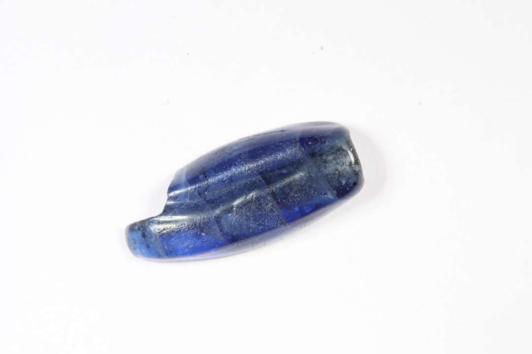 Halv cylindrisk, kubisk, aflang fladtrykt. 4-5 omviklinger af glasset. Bl�. L�ngde: 1,6 cm.