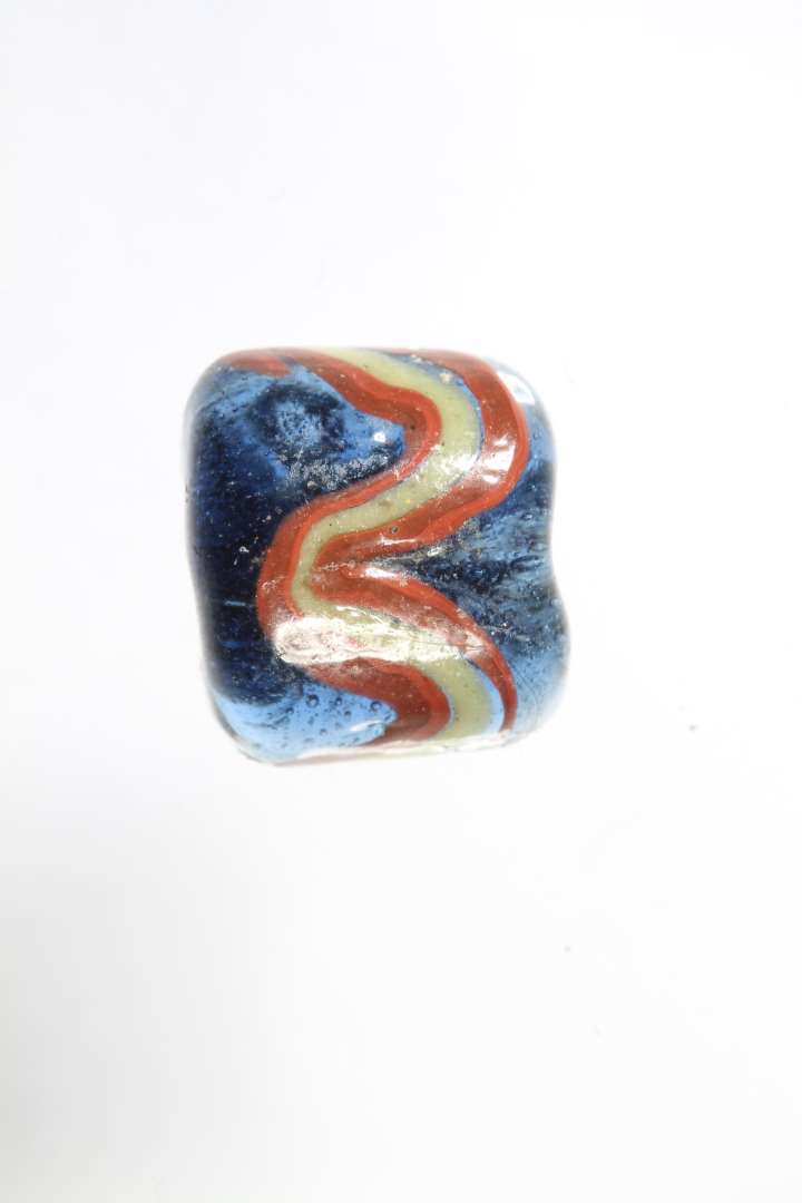 Fragment af cylindrisk ribeperle, gennemsigtig bl� med r�dt og gult. diameter: 1,1 cm.