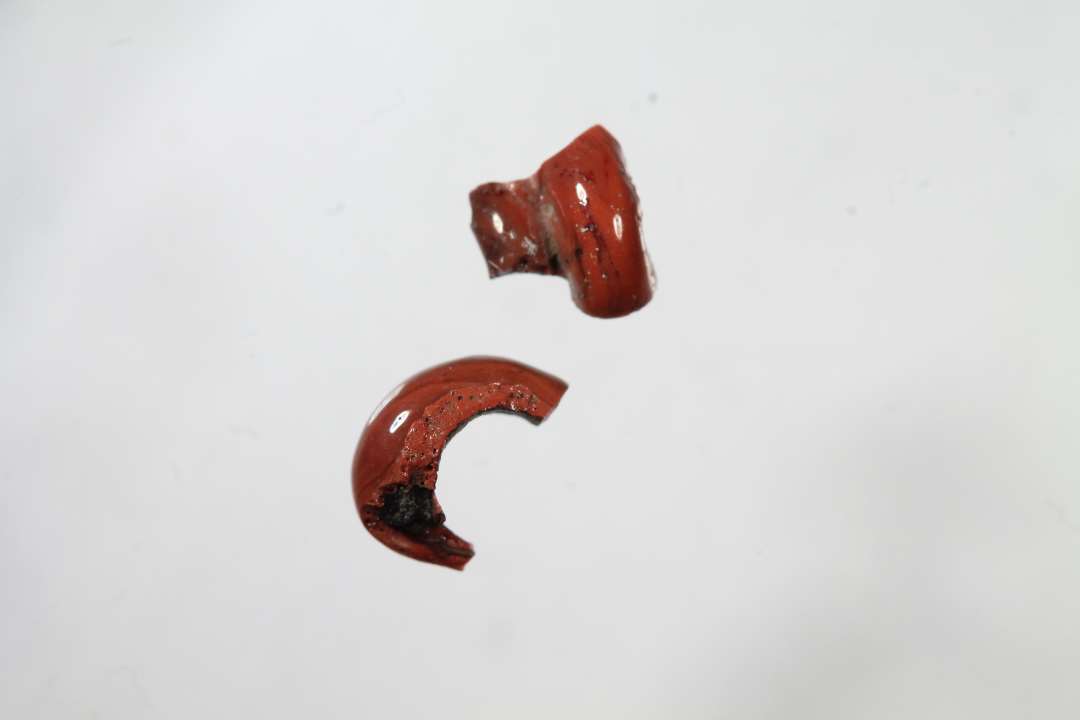 To sammenh�rende? fragmenter af cylindrisk, snoet, uigennemsigtig, r�d glasperle