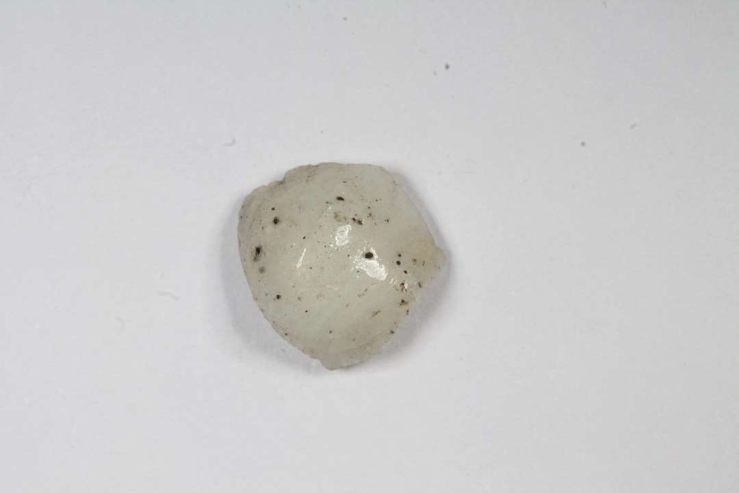 Halv dobbeltkonisk, uigennemsigtig, hvid-gr� glasperle. St�rste m�l: 0,9 cm.