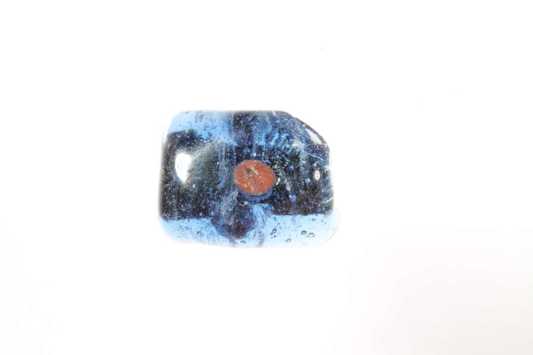 Tre halve polyhydride, polyedriske gennemsigtige bl� glasperler med r�dt