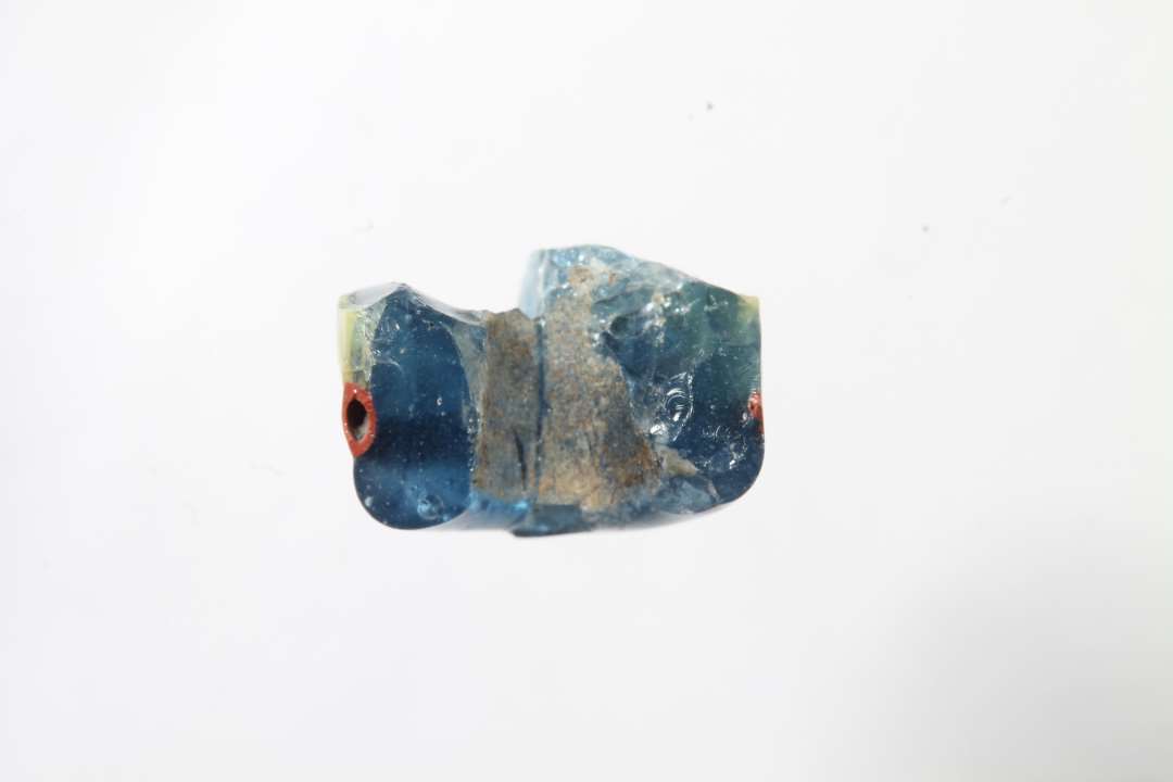 Tre fragmenter af cylindriske ribeperler, gennemsigtig bl� med r�dt og gult. To af fragmenterne er sammenh�rende/sammenlimet