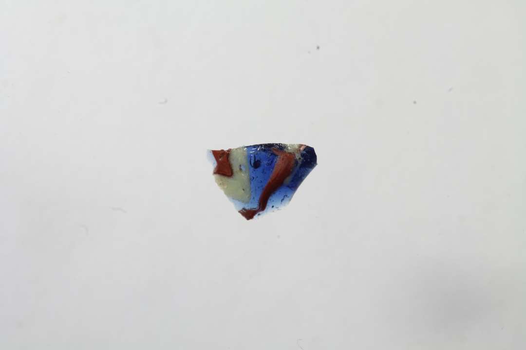 Tre fragmenter af cylindriske ribeperler, gennemsigtig bl� med r�dt og gult. To af fragmenterne er sammenh�rende/sammenlimet