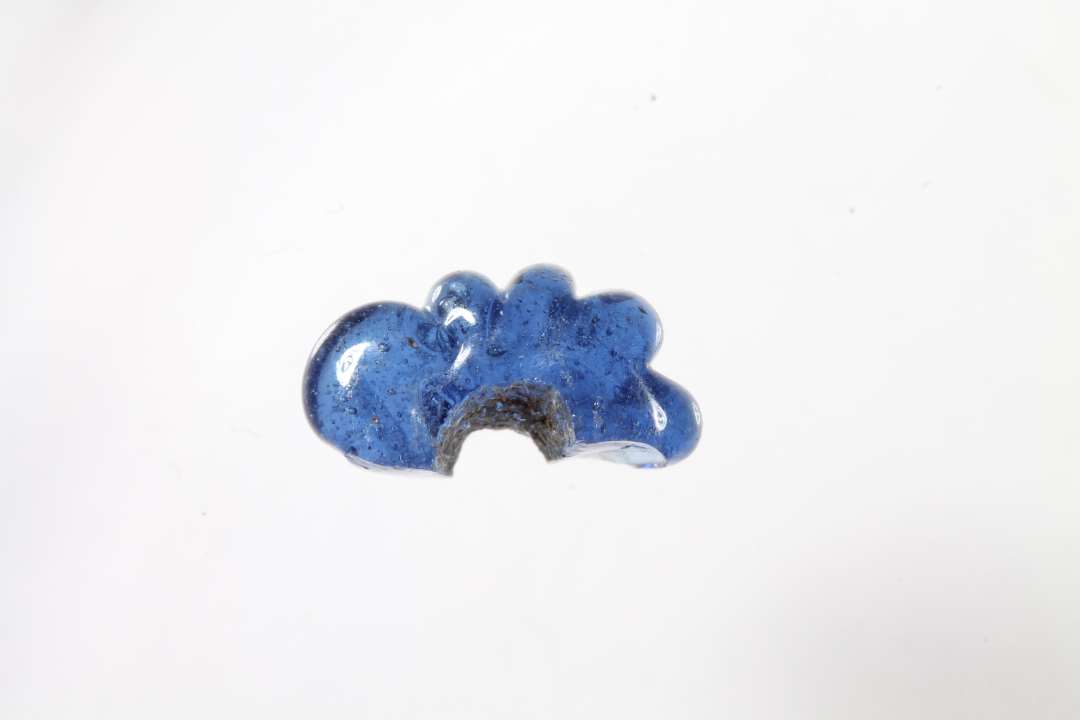 Halv ringformet, melonformet, gennemsigtig, bl� glasperle. Diameter: 1,1 cm. 