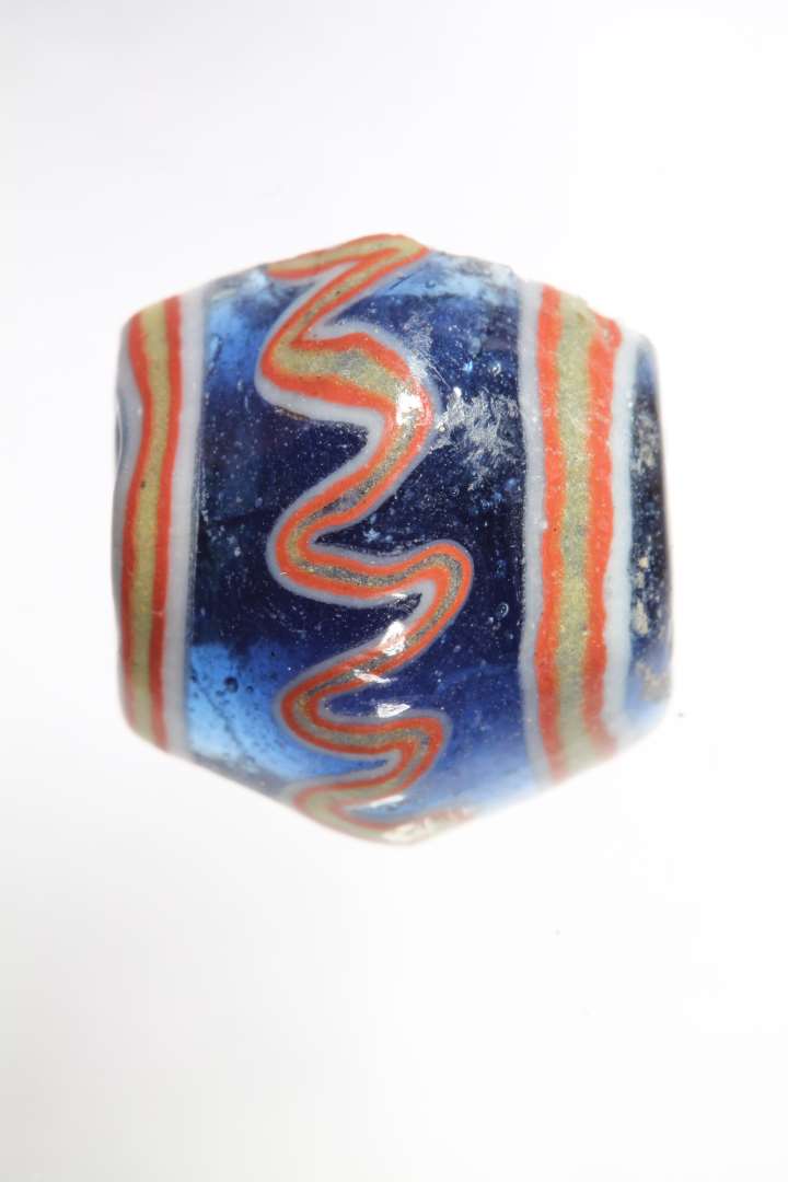 Halv dobbeltkonisk, stor  ribeperle. gennemsigtig bl� med r�dt, hvidt og gult. diameter: 1,6 cm.