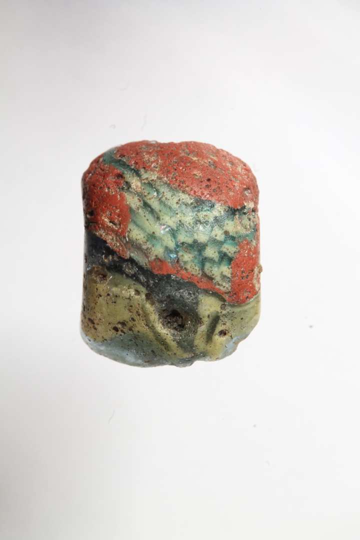 Halv t�ndeformet mosaikperle, halvgennemsigtig, bl� med r�dt, gult og hvidt. Diameter: 1,2 cm.