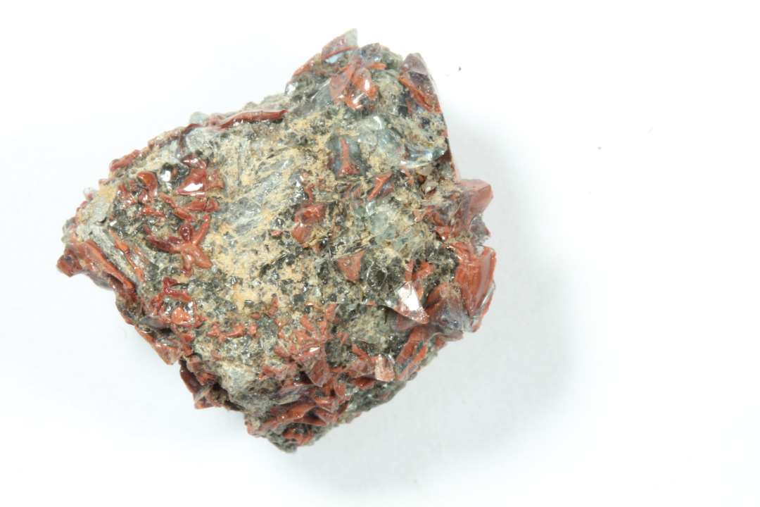 Glasslagge. Ugennemsigtig. R�d samt lidt gr�nt glas.�Fastsmeltet til firkantet 'tesseralignende' blok, ca. 1x1x1 cm.