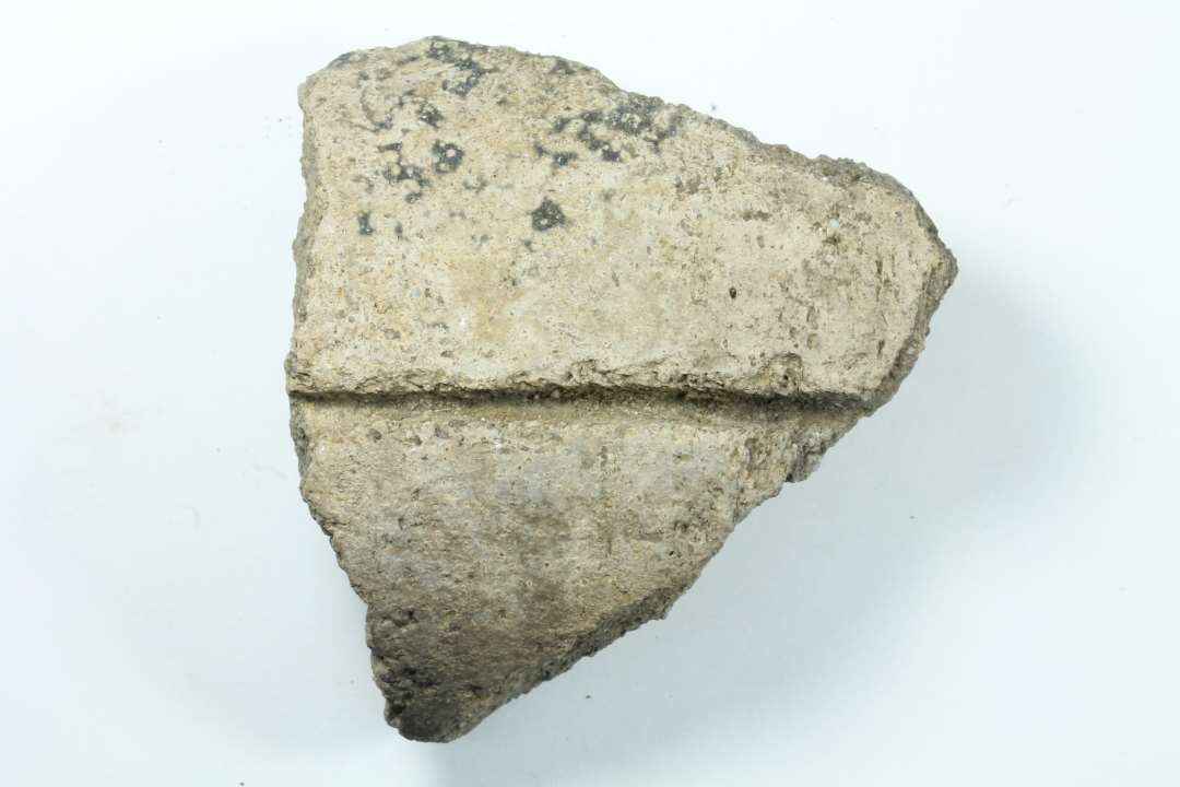 Fragment af kegleformet op til�2,7cm tyk lergenstand, med dyb lodret fure p� ydersiden.
