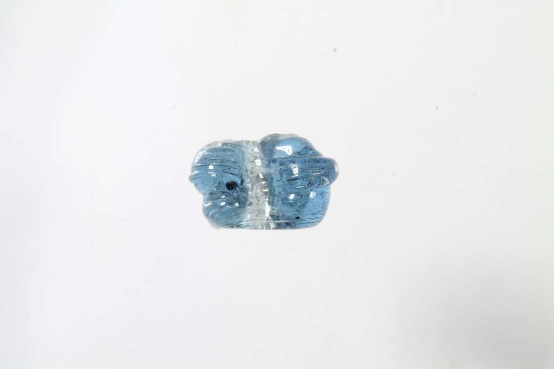 Fragment af ringformet, melonformet, gennemsigtig bl� glasperle. Ikke helt alm. type