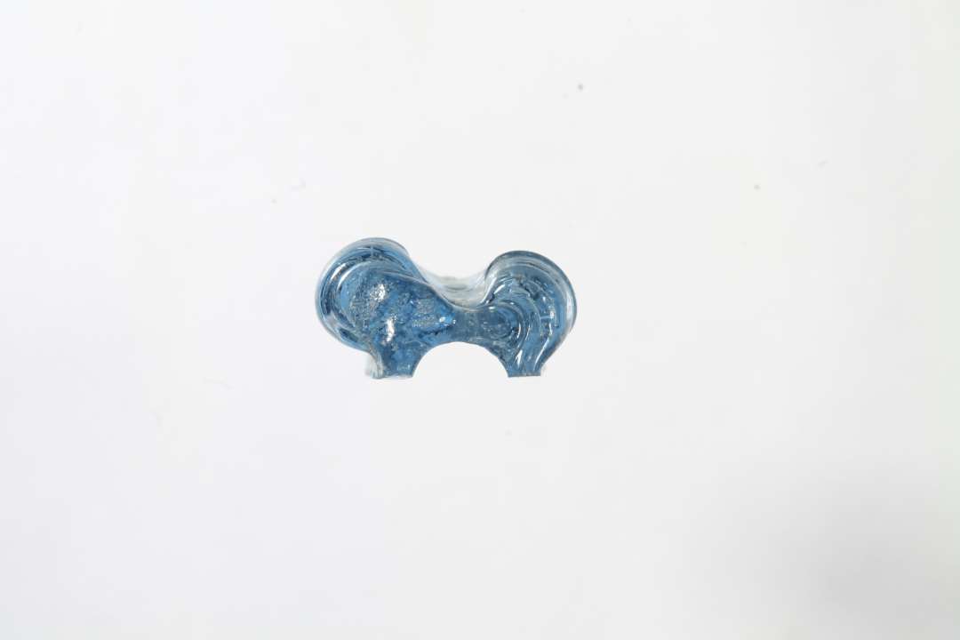 Fragment af ringformet, melonformet, gennemsigtig bl� glasperle. Ikke helt alm. type