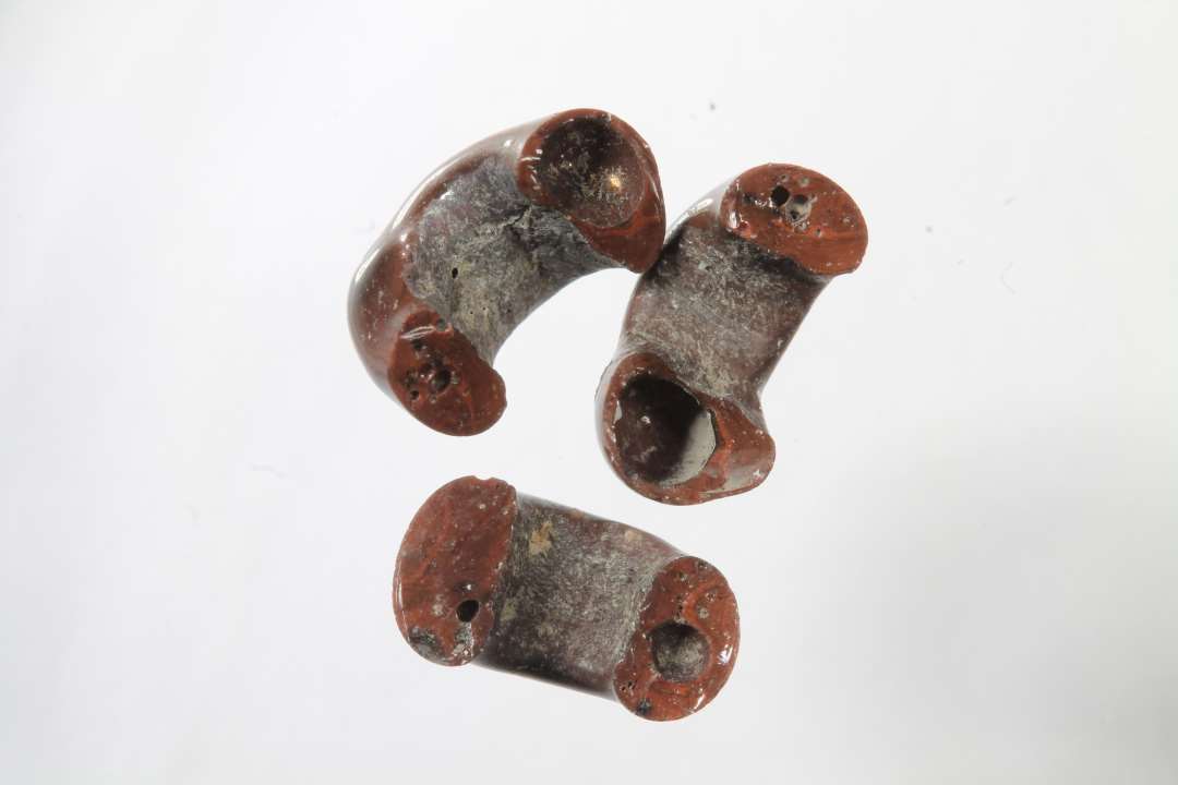 Tre halve ringformede, uigennemsigtige, r�dbrune glasperler