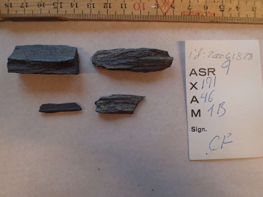 4 fragmenter af hv�ssesten af m�rkegr� skifer. Uden slibeflader. M�l: 2,6-5 cm.
