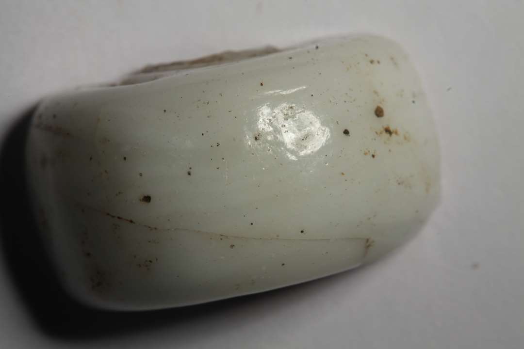 Halv cylindrisk, stor perle af hvid, uigennemsigtig glasmasse. Diameter: 2 cm.