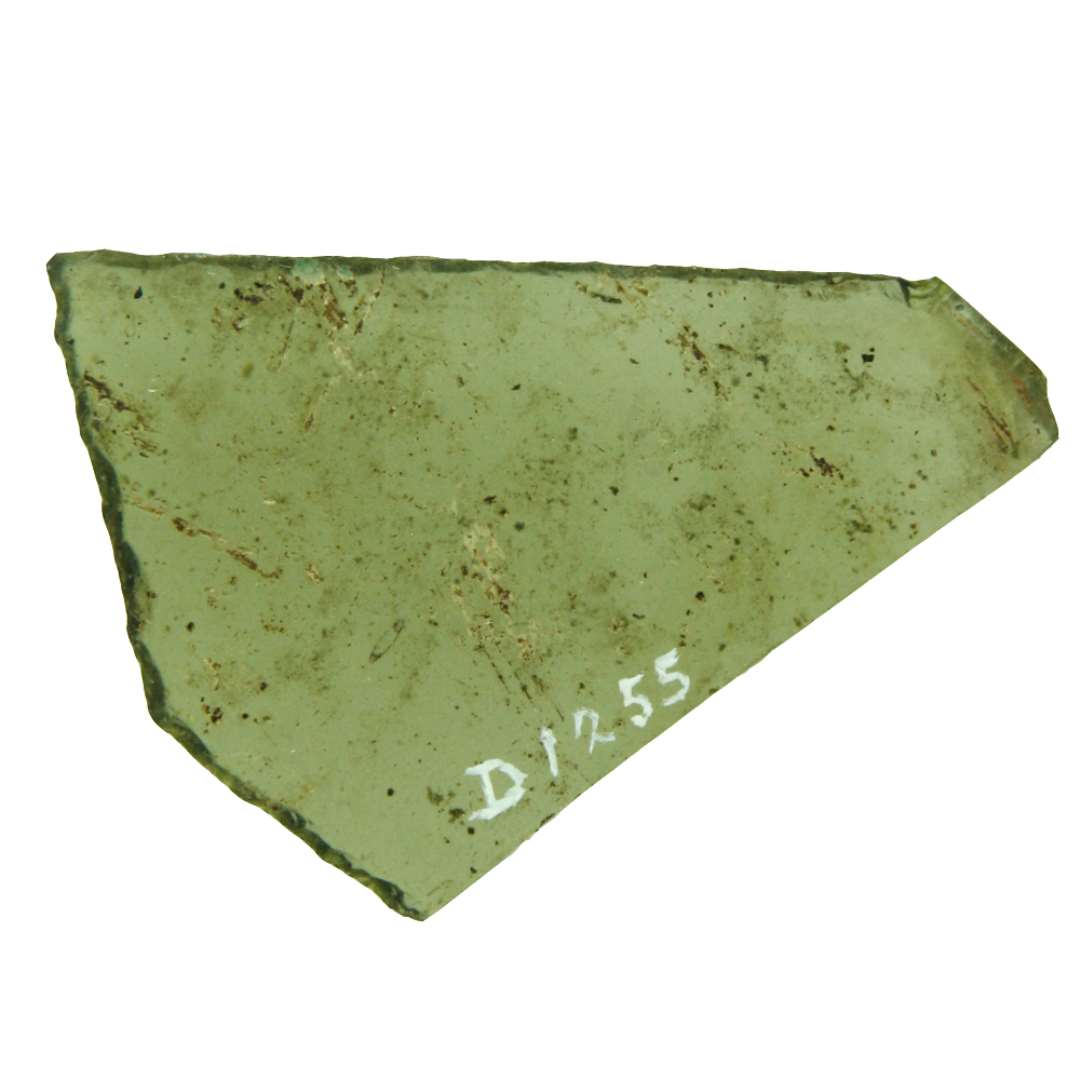 1 rudefragment af klart, gr�nligt glas tildels med afnappede kanter, det udviser 2 stumpe og 1 spids vinkel og har trapetzform med den bevarede ende afsluttet i en spids vinkel. Fragmenterne hidr�rer antagelig fra rude af 6 sidet form. Afstanden mellem de to paralelle sider er ca. 5,8 cm.