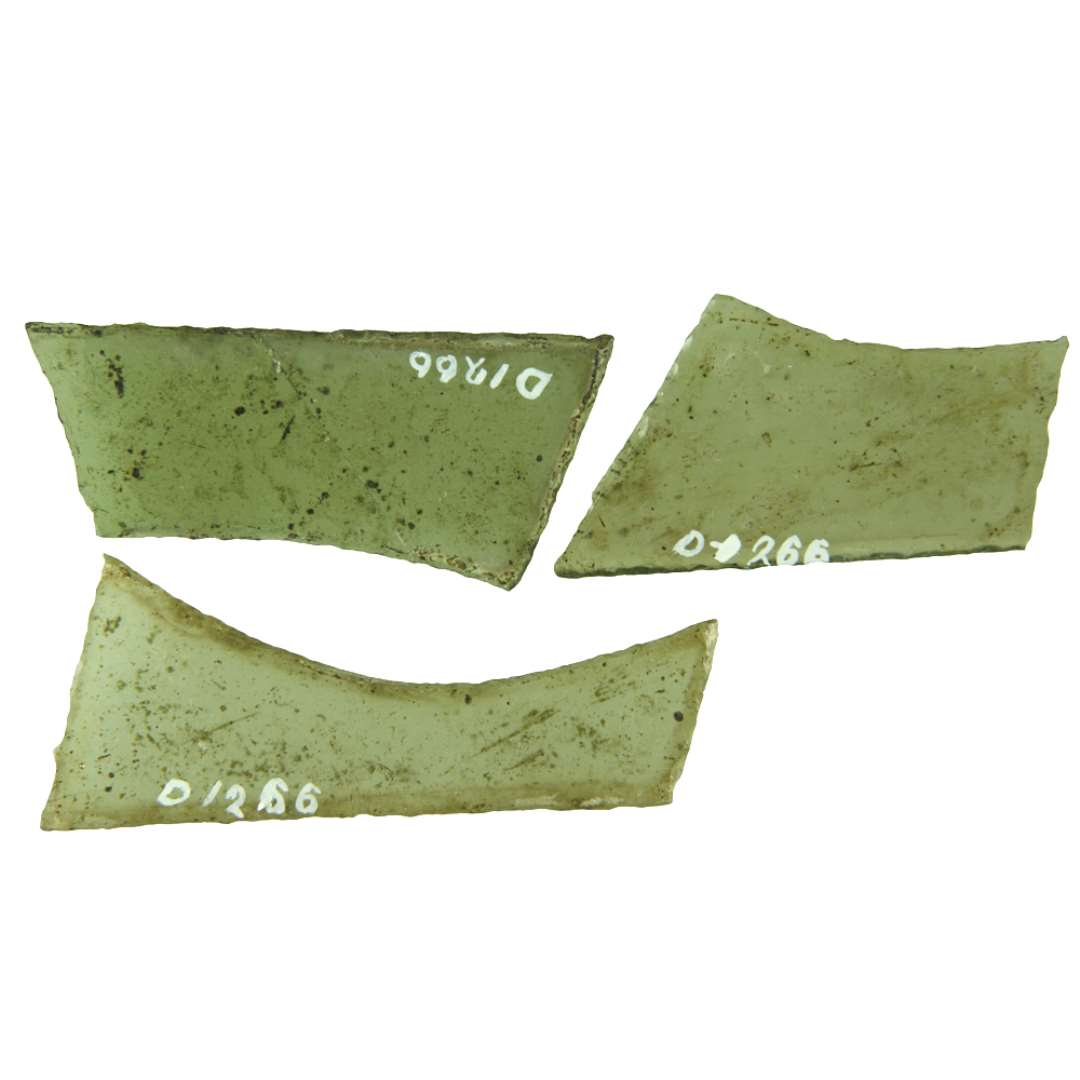 3 hele ruder af klart gr�nligt glas med afnappede kanter. De 2 af ruderne har omtrentlig parlellogramform, den ene trapetzform idet dog den ene langside p� dem alle tre er konkavt indadsvunget. Rudernes st�rste m�l henholdsvis: 3,3 x 6,5 - 3,1 x 7,0 - 3,3 x 8,4 cm.