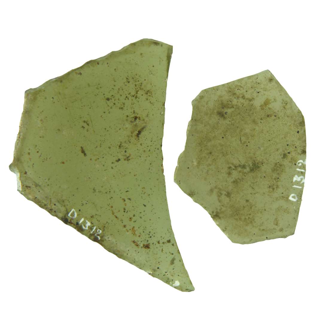 2 rudefragmenter af gulligt glas med delvis afnappede kanter. Hver har en kort side fuldt bevaret og denne m�des med de tilst�dende, l�ngere delvis afbrudte sider i 2 stumpvinklede hj�rner.�St�rste m�l henholdsvis: 5,4 x 4,7 cm. og 7,8 x 6,6 cm.