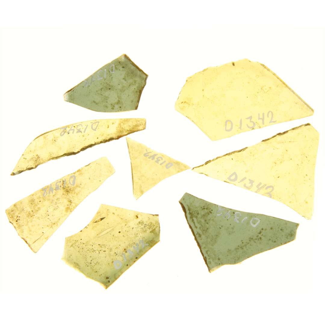 10 rudefragmenter af bl�ligt glas, der alle udviser en eller to sider med afnapning i kanten, en enkelt side har afrundet smelterand, men rudernes form er i�vrigt ikke n�rmere bestemmelig.�Dimension fra 2,2 x 2,9 cm. til 3,7 x 5,4 cm.