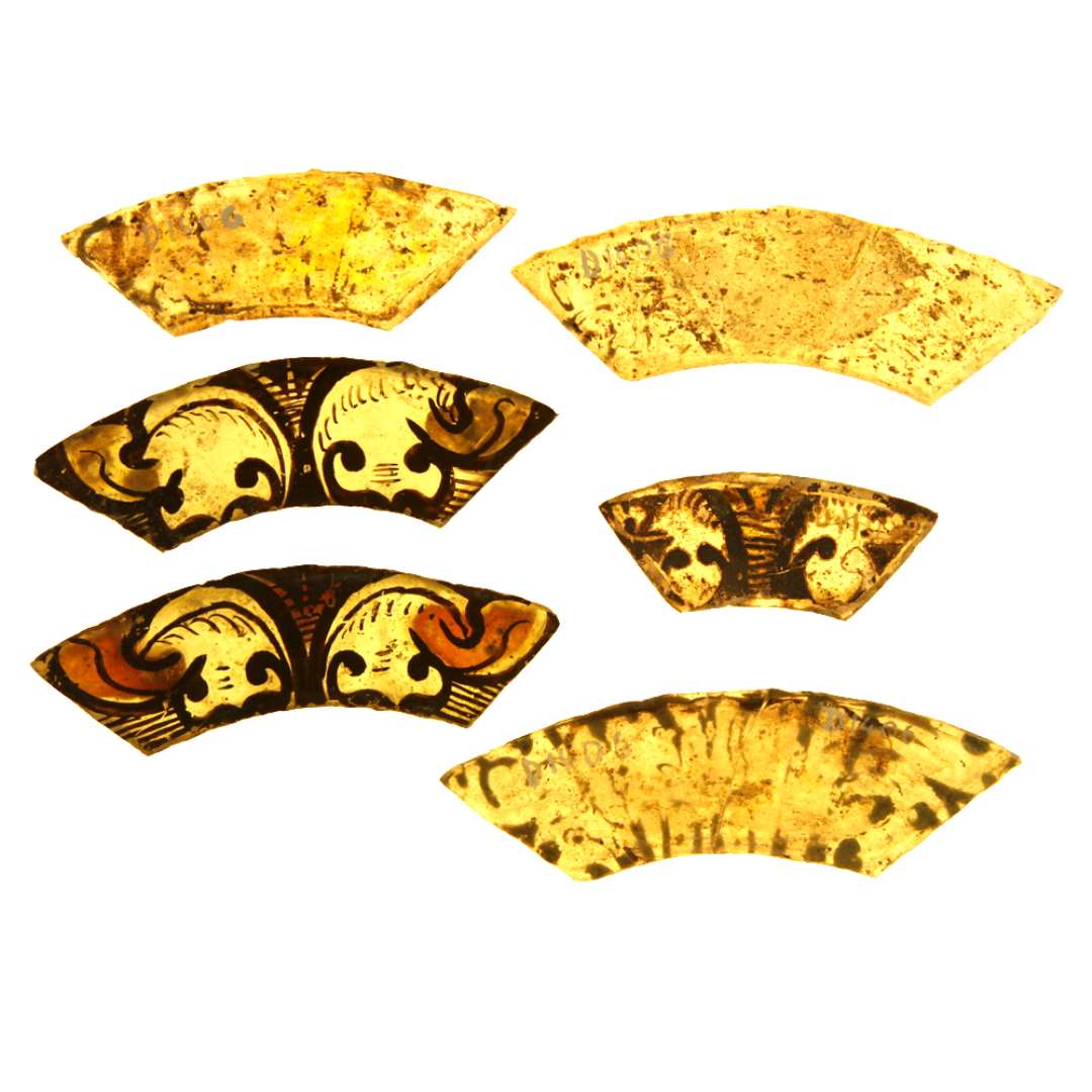 6 hele ruder af klart gr�nligt glas med afnappede kanter bemalet med stiliserede planteornamenter i symetrisk form brunlig tildels afskallet farve. Ruderne viser desuden spor af gul farve. Ruderne har krum rektangul�r b�ndform med skr�t afsk�rne spidse ender.�St�rste m�l: 2,25 x 5,7 cm. - 2,5 x 7,9 cm. - 2,4 x 8,8 cm. - 2,7 x 9,4 cm. - 2,7 x 9,6 cm. - 2,5 x 8,8 cm.