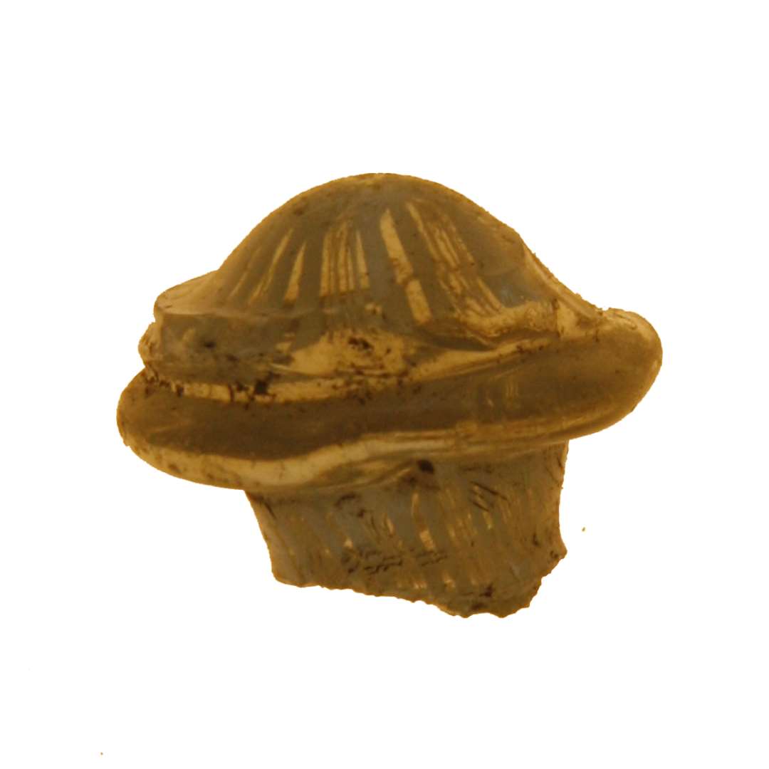 Fragmenteret glasknop, af klart glas i paddehatformet overbrudt i stilken t�t under 'hatten' hvis rand har form af en aftrappet, fremst�ende vulst. 'Hattens' overside er prydet med et m�nster af indsmeltede, m�lkehvide glastr�de anbragt i rosetform med parvis h�rtynde og tykkere imellem hinanden. 'Stilken' er forsynet med de samme tr�de, men her anbragt i let tovsnoet form. Knoppens st�rste h�jde: ca. 1,5 cm. st�rste bredde: ca. 1,8 cm.