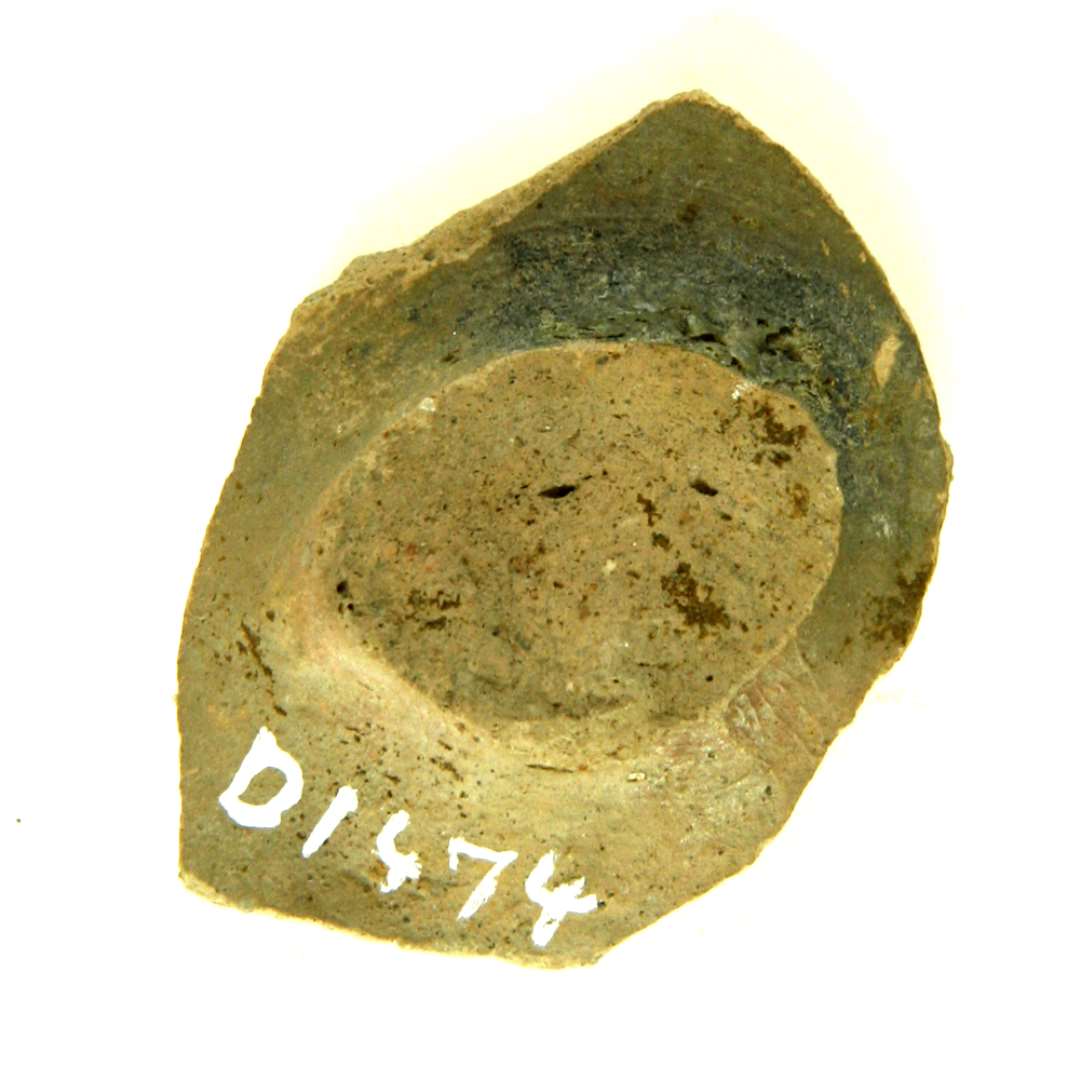 bugsk�r af stjertpotte af gr�brunligt lergods med ar efter afbrudt t�. Sk�rets inderside udviser en plan bundflade med tynd gr�nlig blyglasur samt en ubetydelig stump af en stejlt opstigende v�gside.