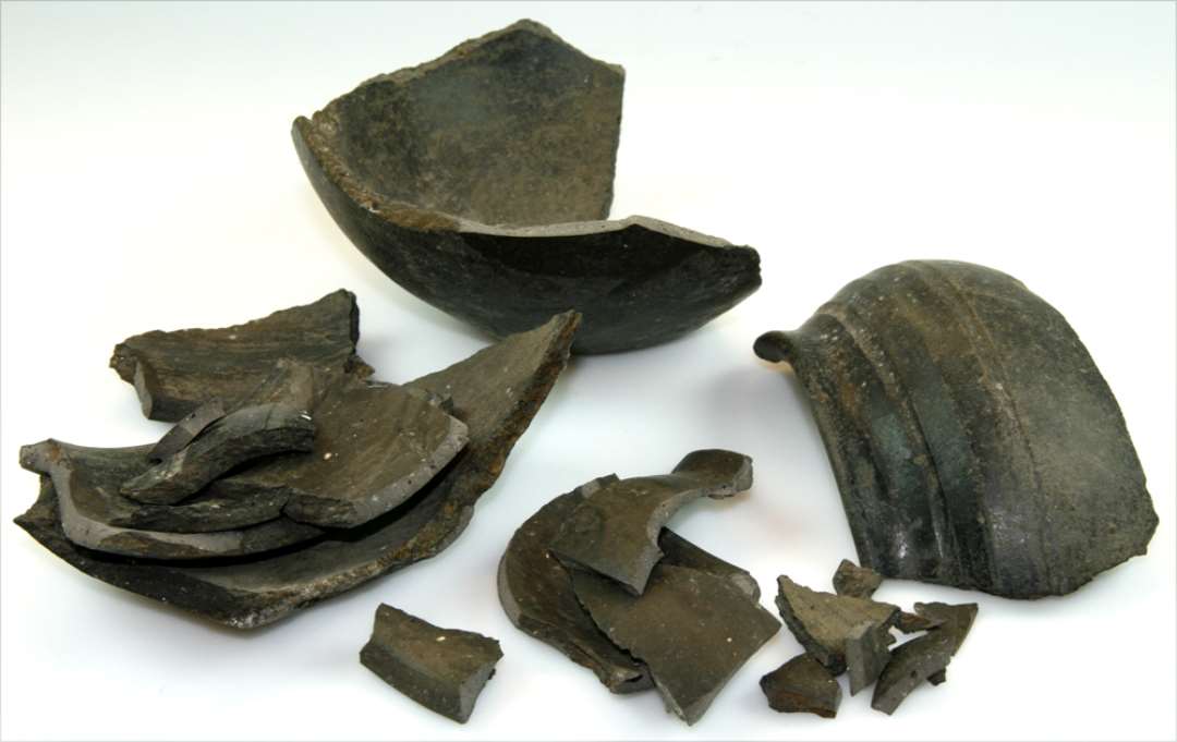 Lerkar. Rundbuget med lillestandflade. Med facetteret, fortykket mundingsrand. Skulderpartiet dekoreret med furer. Itu. H�jde: 12 cm., muningsdiameter: 14 cm.