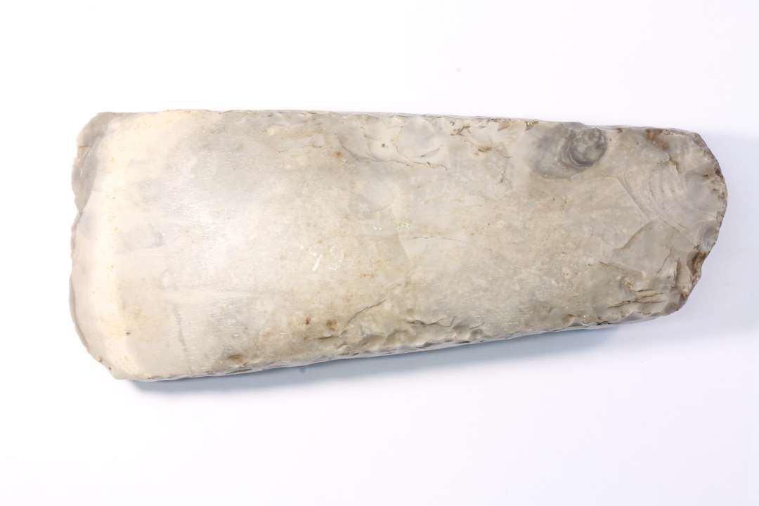 Tyndnakket �kse af Flint, 18 Cm. lang og 7 cm. bred. Hv�lvede Bredsider og sleben paa alle fire Sider. Eggen beskadiget under Brugen.